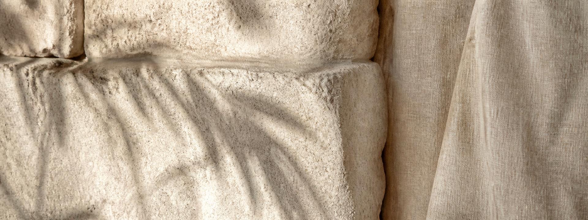Close detail of Balinese stone and raw linen in warm afternoon light